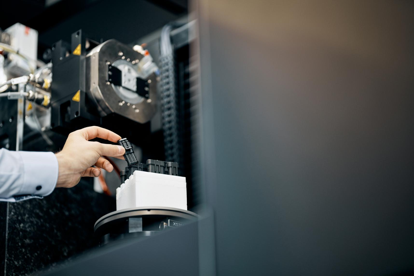 Additive manufacturing engineer puts a plastic part into a computed tomography machine