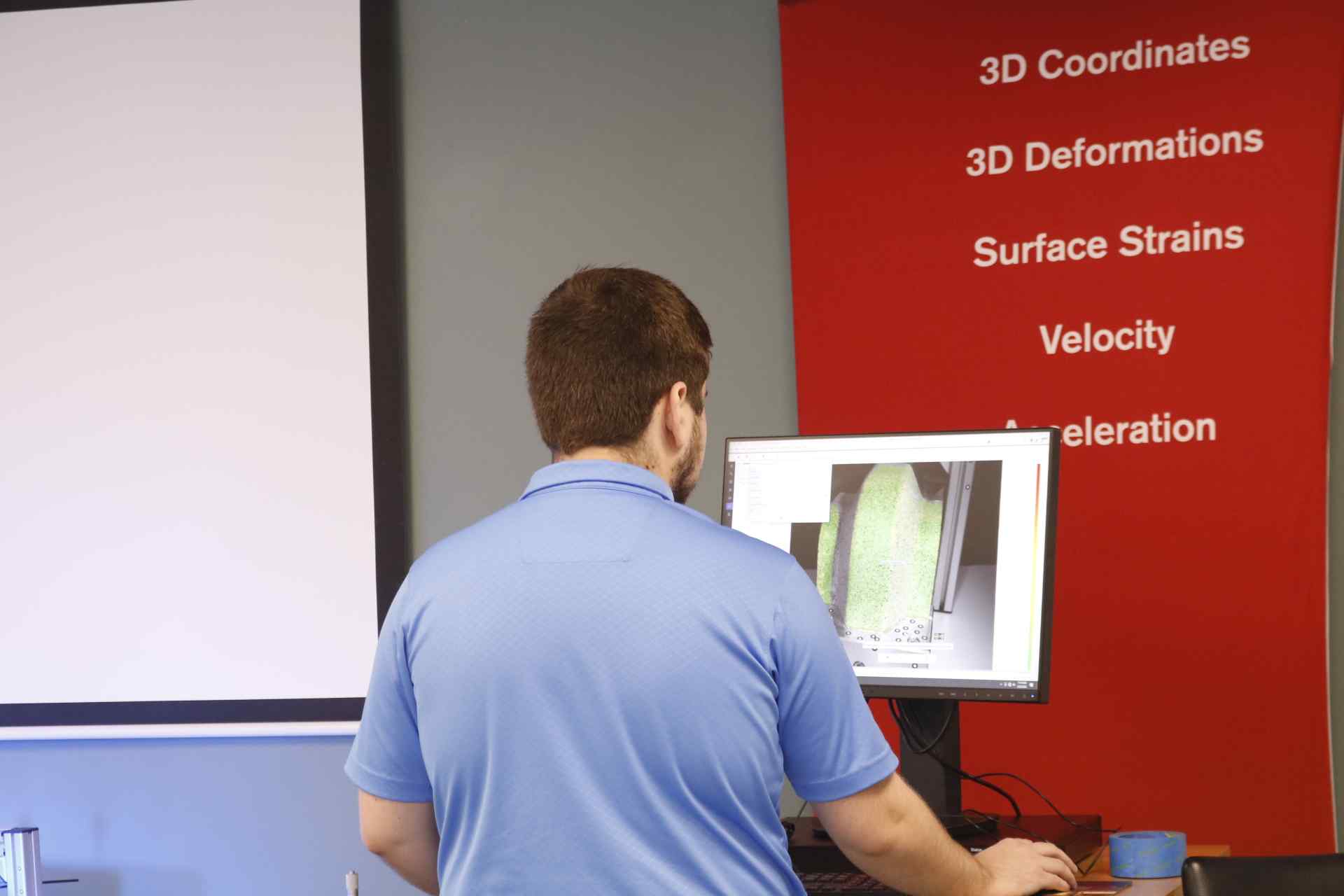 Engineering Trainee looks over digital image correlation data