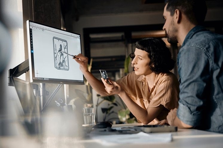 Female engineer explaining important scan data in the GOM Scan 1 software of a 3D part to a male engineer